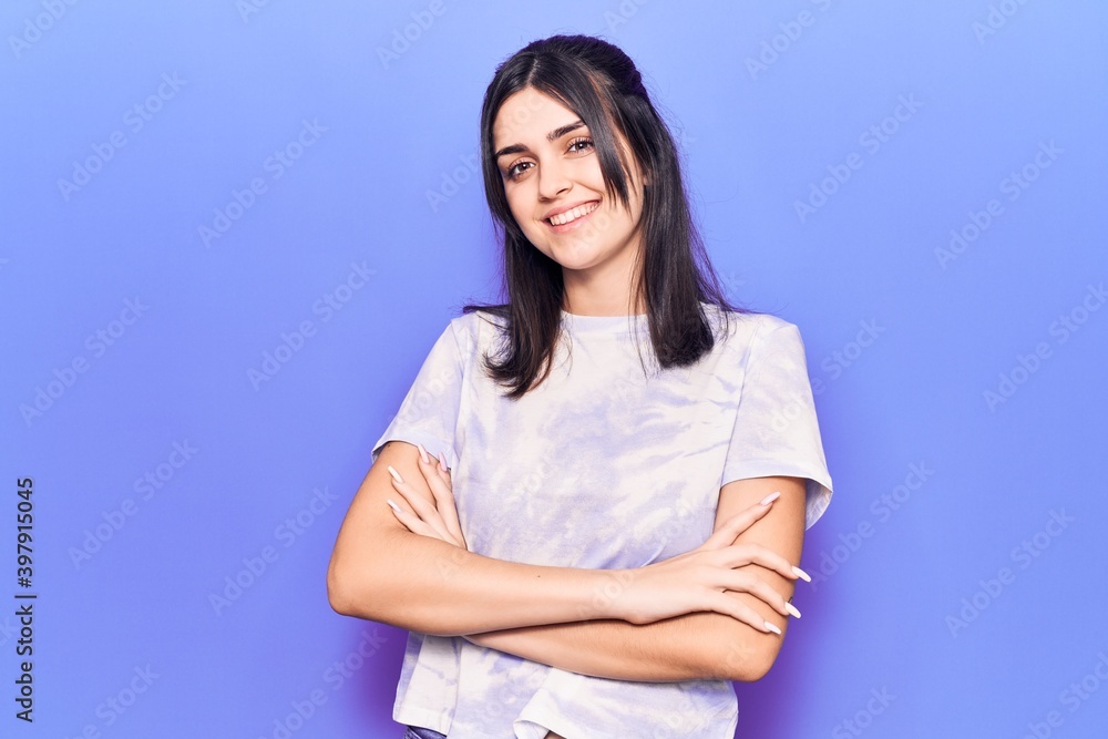 Young beautiful girl wearing casual t shirt happy face smiling with crossed arms looking at the camera. positive person. Young beautiful girl wearing casual t shirt happy face smiling with crossed arms looking at the camera. positive person.