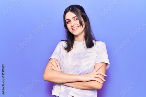 Young beautiful girl wearing casual t shirt happy face smiling with crossed arms looking at the camera. positive person.