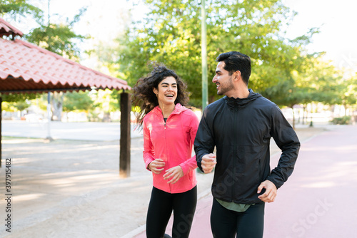 Smiling couple running in the park track