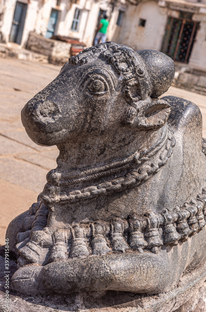 Hampi, Karnataka, India - November 4, 2013: Virupaksha Temple complex. Closeup of gray-black statue of Nandi head on courtyard in front of Shiva Sanctum. 