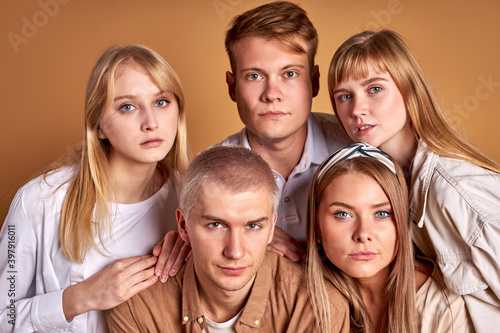 unusual group of extraordinary youth posing in trendy wear, caucasian models confidently look at camera isolated in studio