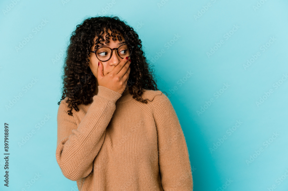 Young african american afro woman isolated thoughtful looking to a copy space covering mouth with hand. Young african american afro woman isolated thoughtful looking to a copy space covering mouth with hand.