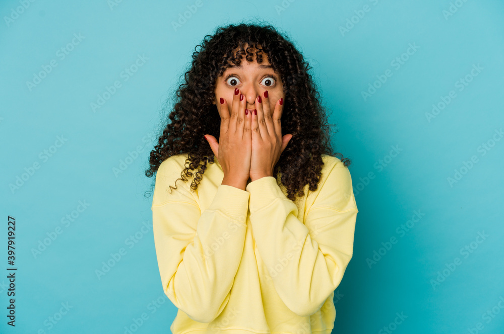 Young african american afro woman isolated shocked, covering mouth with hands, anxious to discover something new. Young african american afro woman isolated shocked, covering mouth with hands, anxious to discover something new.