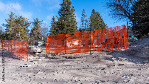 Orange snow fence set up on beach photo