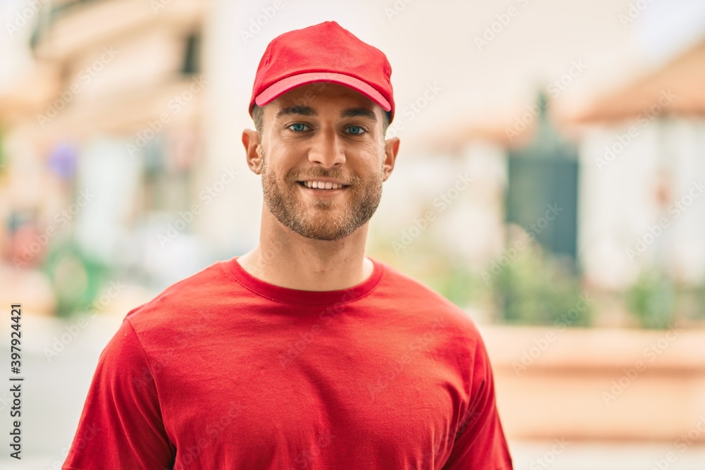 Young caucasian deliveryman smiling happy standing at the city. Young caucasian deliveryman smiling happy standing at the city.