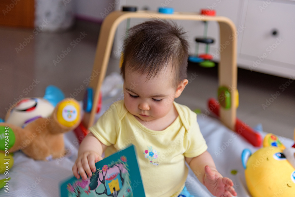Bebe pequeño con juguetes en casa con vestido amarillo Bebe pequeño con juguetes en casa con vestido amarillo