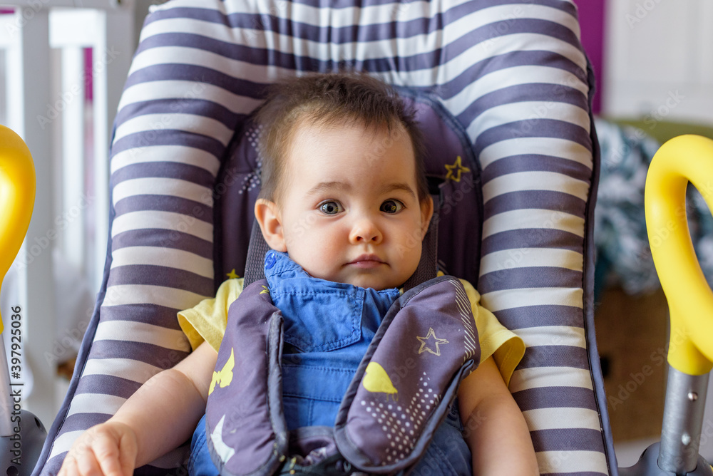 bebe niña pequeña tumbada en camita de bebe a rallas en casa bebe niña pequeña tumbada en camita de bebe a rallas en casa