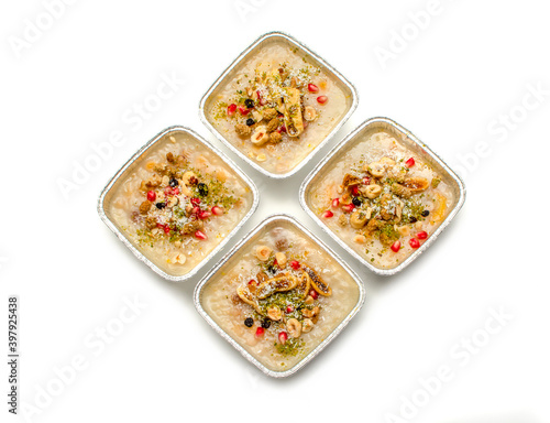 Closeup of traditional Turkish Dessert Asure or Ashura (aka Noah Pudding) in disposable aluminum bowls isolated on white background. with copy space for text. 