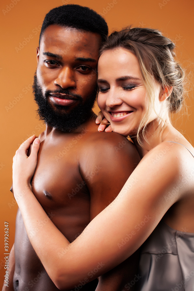 young pretty couple diverse races together posing sensitive on brown background, lifestyle people concept young pretty couple diverse races together posing sensitive on brown background, lifestyle people concept