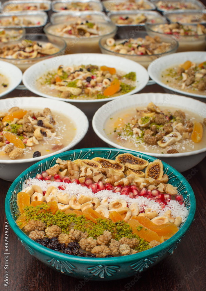 Closeup of traditional Turkish Dessert Asure or Ashura (aka Noah Pudding) in white bowls isolated on black backgroun Closeup of traditional Turkish Dessert Asure or Ashura (aka Noah Pudding) in white bowls isolated on black backgroun
