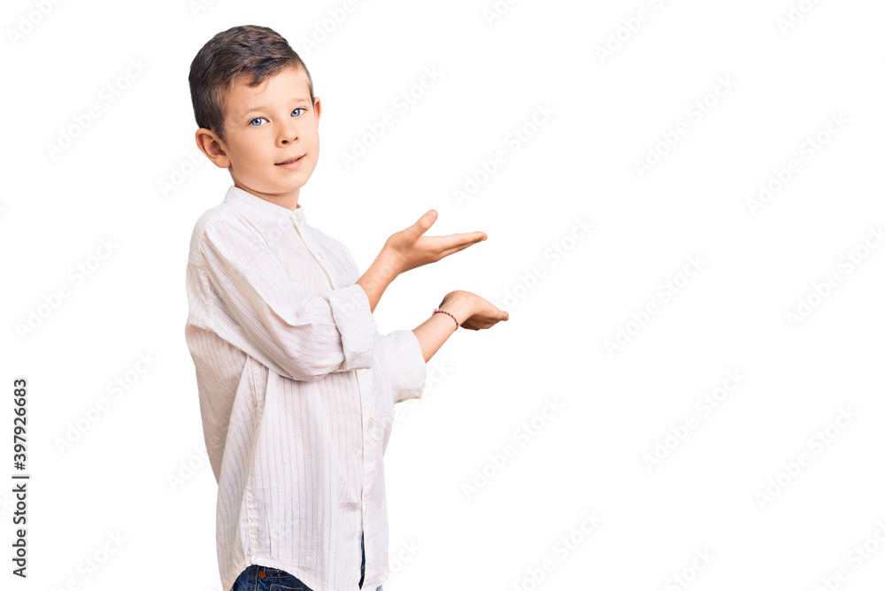 Cute blond kid wearing elegant shirt inviting to enter smiling natural with open hand Cute blond kid wearing elegant shirt inviting to enter smiling natural with open hand