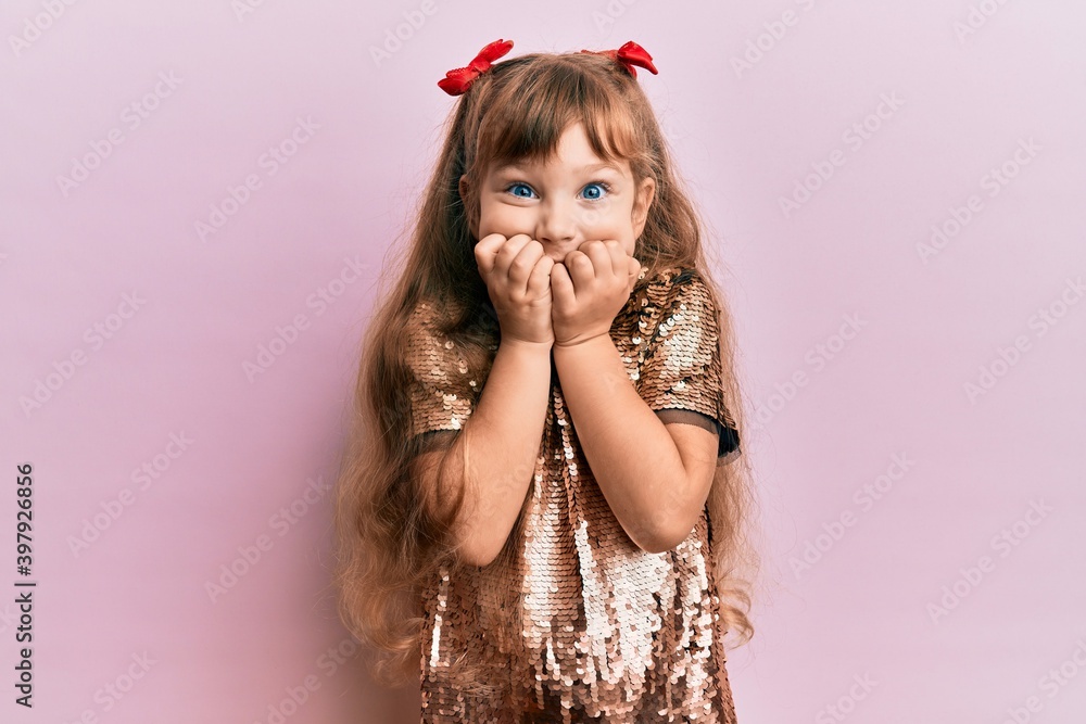 Little caucasian girl kid wearing festive sequins dress looking stressed and nervous with hands on mouth biting nails. anxiety problem. Little caucasian girl kid wearing festive sequins dress looking stressed and nervous with hands on mouth biting nails. anxiety problem.