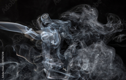 Abstract puffs of smoke on a black background.