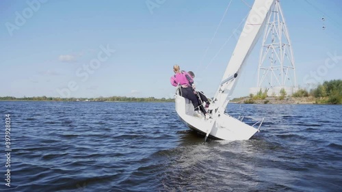 Three athletes are transferred to the other side of the sailing boat while driving the boat at the regatta. Slow motion