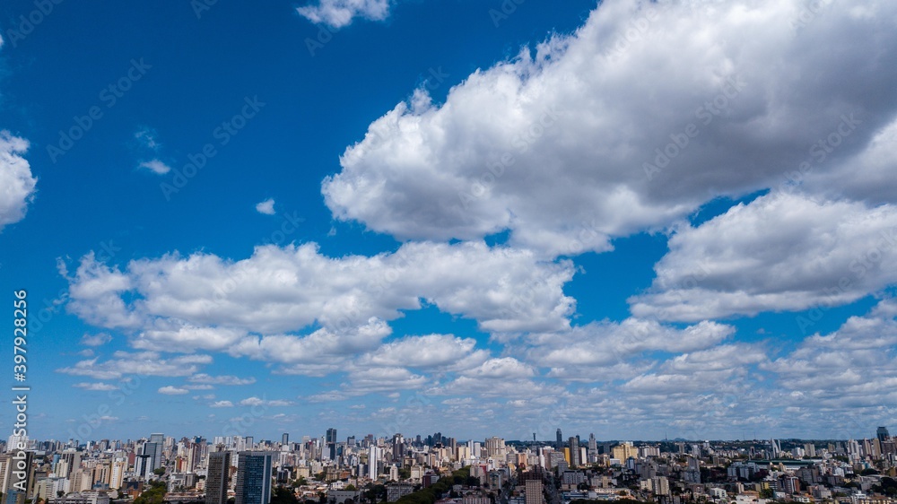 Panoramic drone view of the Alto de XV neighborhood, in the upper third the blue sky with clouds, below and in the background the center of Curitiba, capital of the state of Paraná, located in the sou Panoramic drone view of the Alto de XV neighborhood, in the upper third the blue sky with clouds, below and in the background the center of Curitiba, capital of the state of Paraná, located in the sou
