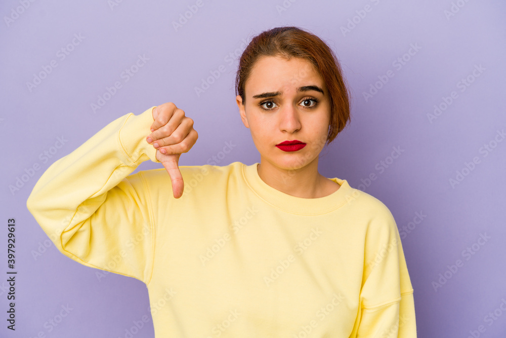 Young arab mixed race woman showing a dislike gesture, thumbs down. Disagreement concept. Young arab mixed race woman showing a dislike gesture, thumbs down. Disagreement concept.