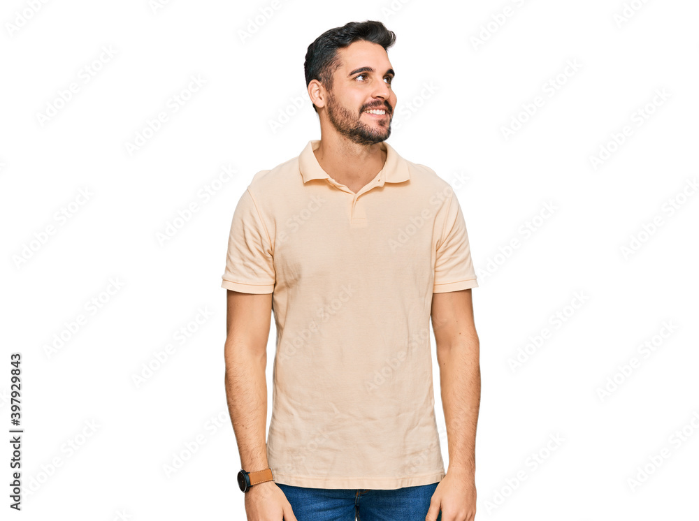 Young hispanic man wearing casual clothes looking away to side with smile on face, natural expression. laughing confident. Young hispanic man wearing casual clothes looking away to side with smile on face, natural expression. laughing confident.