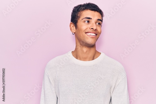 Young african amercian man wearing casual clothes looking to side, relax profile pose with natural face and confident smile.