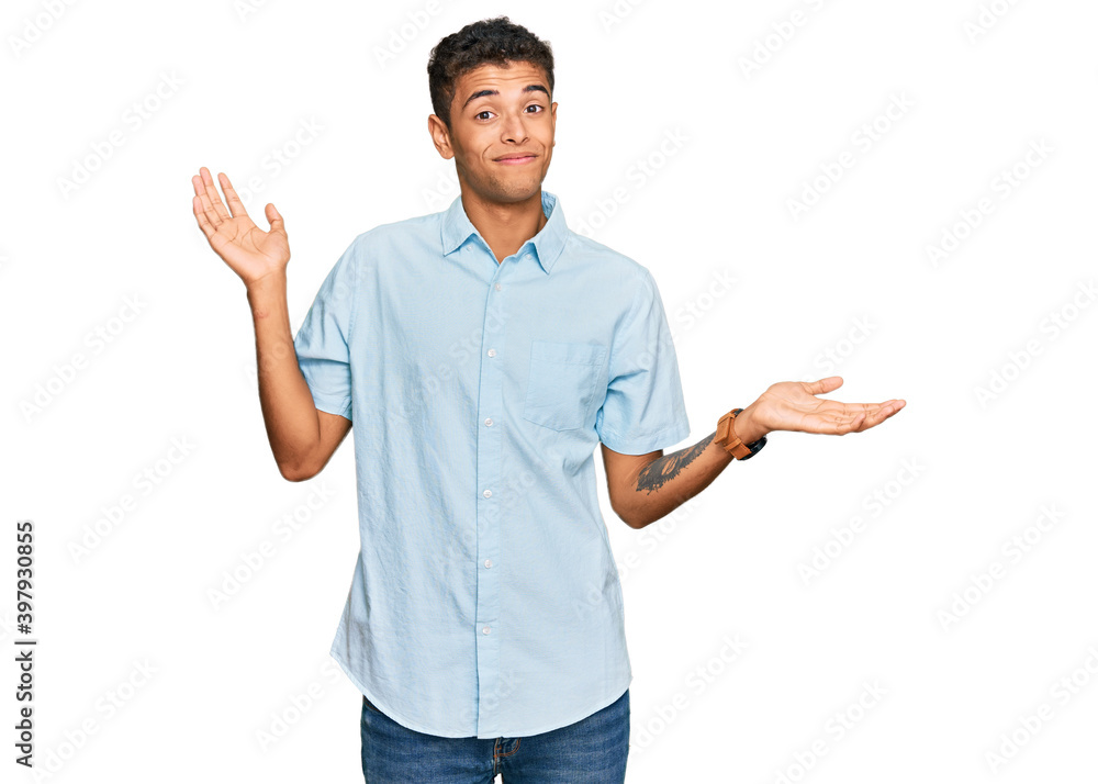 Young handsome african american man wearing casual clothes clueless and confused expression with arms and hands raised. doubt concept. Young handsome african american man wearing casual clothes clueless and confused expression with arms and hands raised. doubt concept.