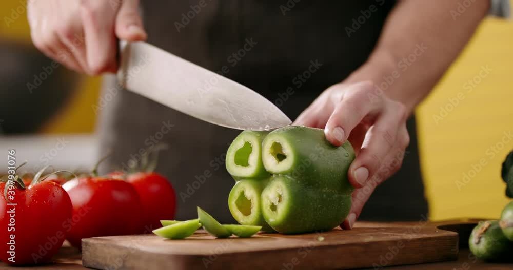 Close up shot of chef's hands using a knife cutting a fresh bell pepper on wooden board. Cooker preparing a vegetarian meal - food and drink 4k footage Close up shot of chef's hands using a knife cutting a fresh bell pepper on wooden board. Cooker preparing a vegetarian meal - food and drink 4k footage