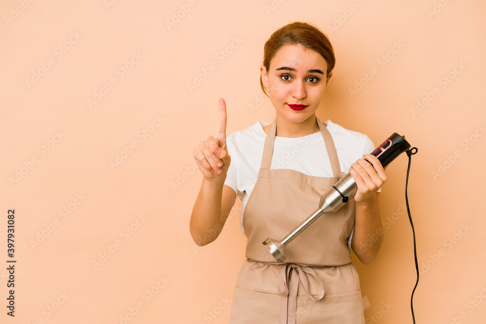 Young skinny arab cook woman showing number one with finger. Young skinny arab cook woman showing number one with finger.