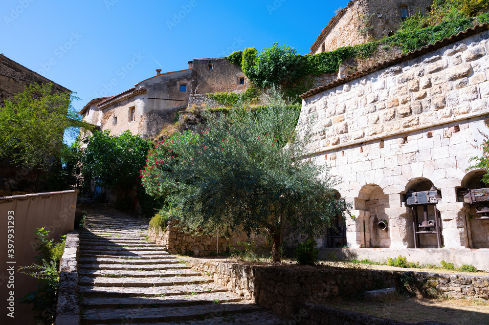 Travel destination, small ancient village Cotignac in Provence, surrounded by vineyards and cliffs with troglodytes houses.