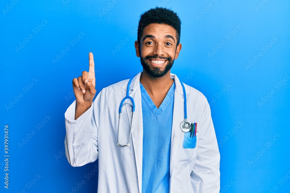 Handsome hispanic man with beard wearing doctor uniform and stethoscope smiling with an idea or question pointing finger up with happy face, number one Handsome hispanic man with beard wearing doctor uniform and stethoscope smiling with an idea or question pointing finger up with happy face, number one