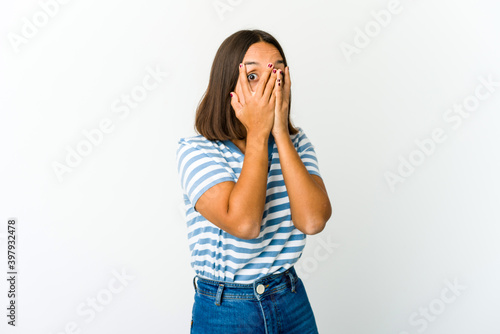 Young mixed race woman blink through fingers frightened and nervous.