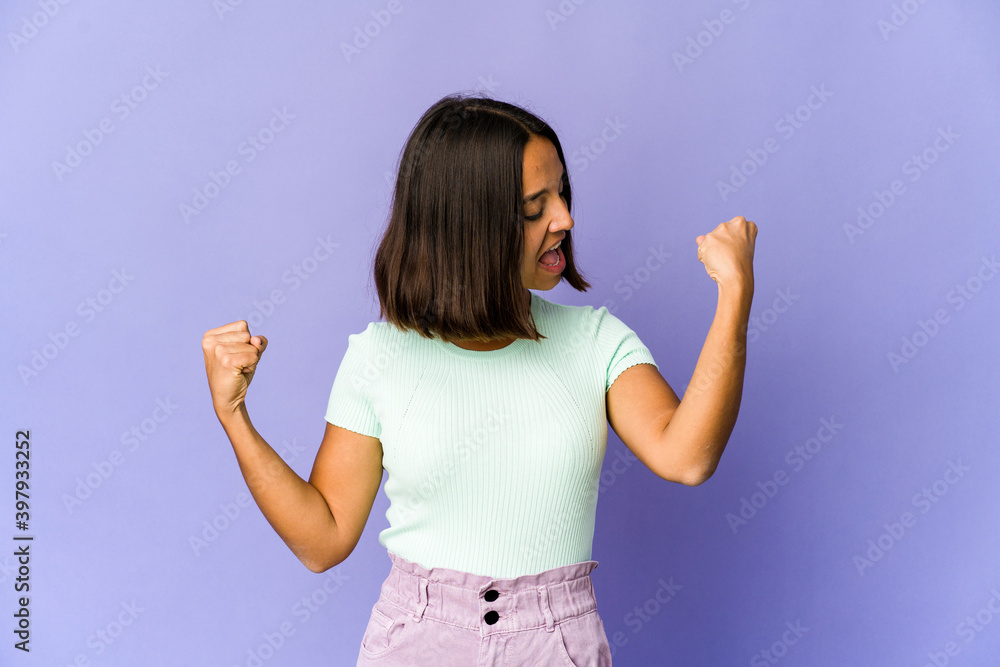 Young mixed race woman showing strength gesture with arms, symbol of power Young mixed race woman showing strength gesture with arms, symbol of power