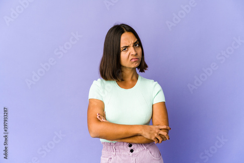 Young mixed race woman unhappy looking in camera with sarcastic expression.