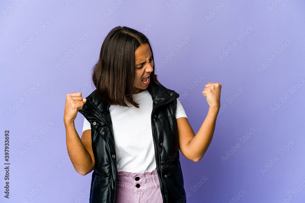 Young mixed race woman raising fist after a victory, winner concept. Young mixed race woman raising fist after a victory, winner concept.