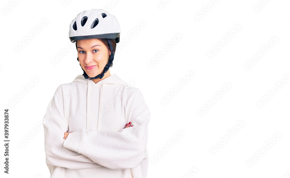 Beautiful brunette young woman wearing bike helmet and sporty clothes happy face smiling with crossed arms looking at the camera. positive person. Beautiful brunette young woman wearing bike helmet and sporty clothes happy face smiling with crossed arms looking at the camera. positive person.