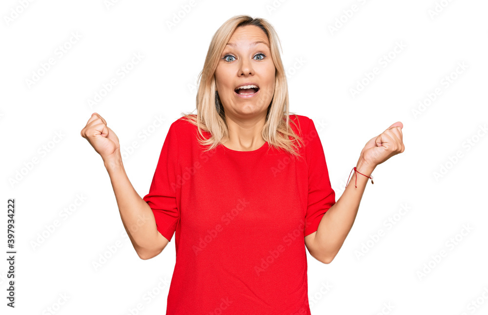 Middle age caucasian woman wearing casual clothes celebrating surprised and amazed for success with arms raised and open eyes. winner concept. Middle age caucasian woman wearing casual clothes celebrating surprised and amazed for success with arms raised and open eyes. winner concept.