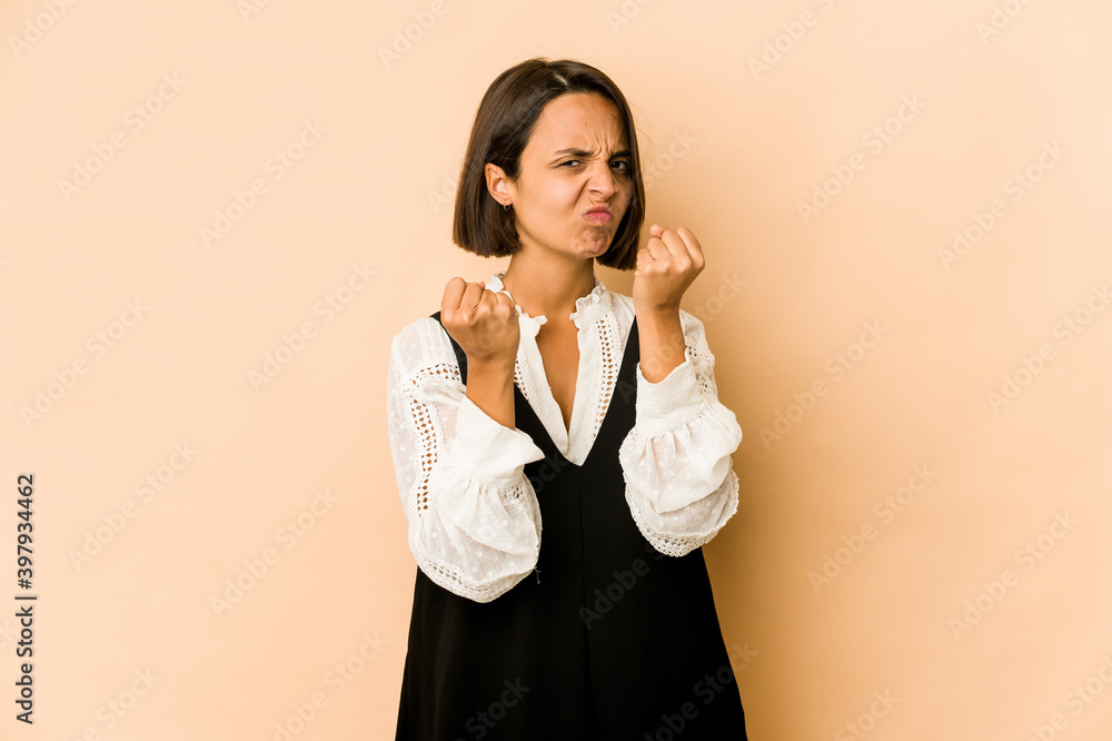 Young hispanic woman isolated showing fist to camera, aggressive facial expression. Young hispanic woman isolated showing fist to camera, aggressive facial expression.