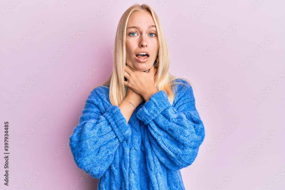 Young blonde girl wearing wool winter sweater shouting and suffocate because painful strangle. health problem. asphyxiate and suicide concept. Young blonde girl wearing wool winter sweater shouting and suffocate because painful strangle. health problem. asphyxiate and suicide concept.