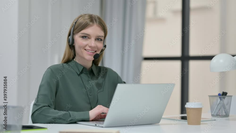 Woman with Headset Smiling while Working on Laptop Woman with Headset Smiling while Working on Laptop