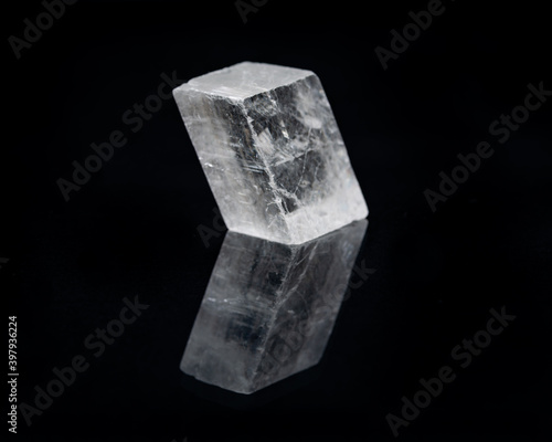 Optical Calcite from China isolated on a black mirror background. Alternative stone name: Iceland Spar.