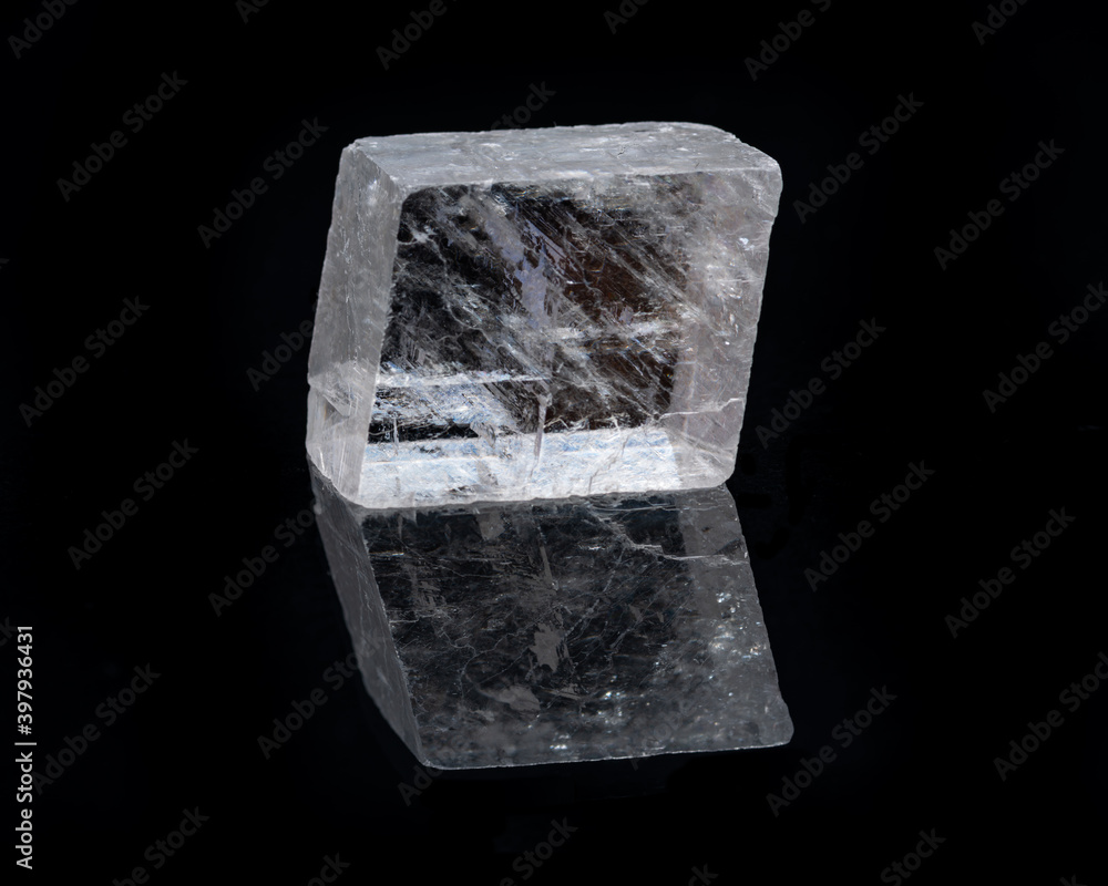 Optical Calcite from China isolated on a black mirror background. Alternative stone name: Iceland Spar. Optical Calcite from China isolated on a black mirror background. Alternative stone name: Iceland Spar.