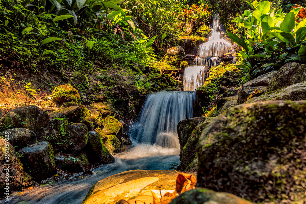 A long exposure of a cascading tropical waterfall in a tropical forest