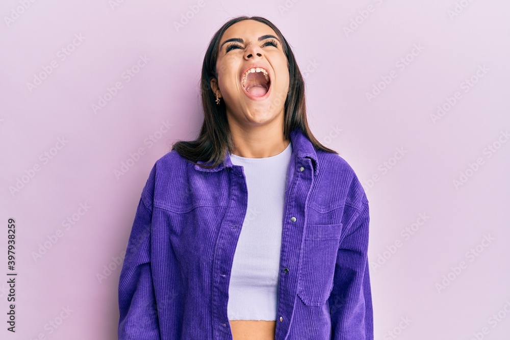 Young brunette woman wearing casual clothes angry and mad screaming frustrated and furious, shouting with anger. rage and aggressive concept. Young brunette woman wearing casual clothes angry and mad screaming frustrated and furious, shouting with anger. rage and aggressive concept.