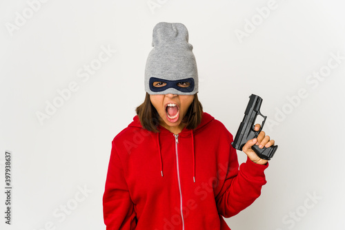 Canvas Print Young robber hispanic woman wearing a mask screaming very angry and aggressive