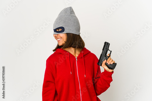 Photo Young robber hispanic woman wearing a mask looks aside smiling, cheerful and pleasant
