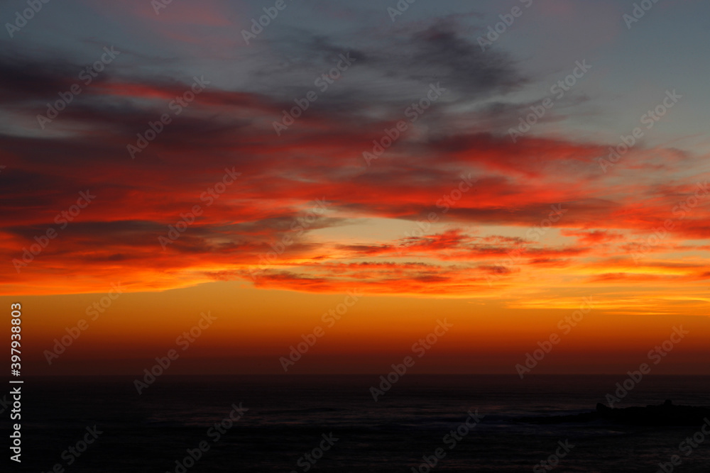 sunset with the reddish sun near the sea