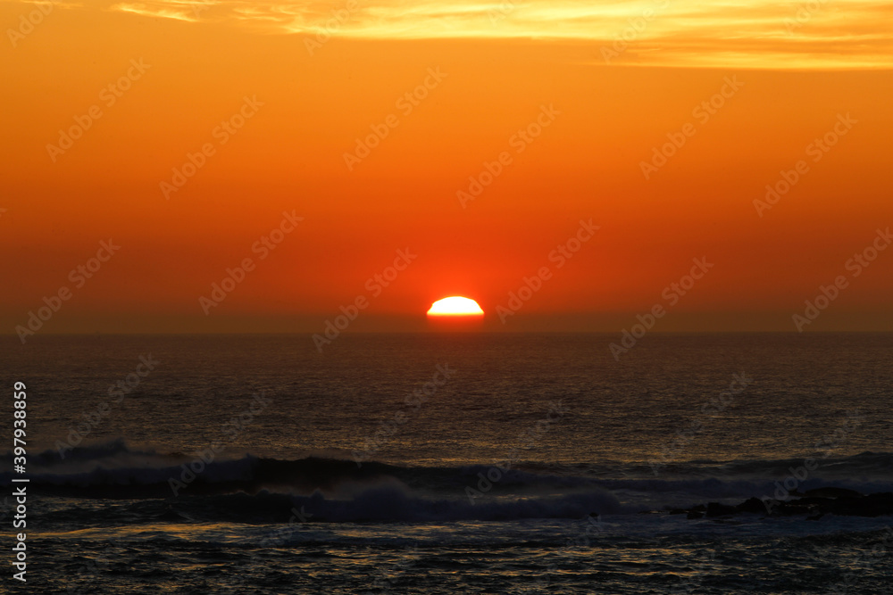sunset with the reddish sun near the sea