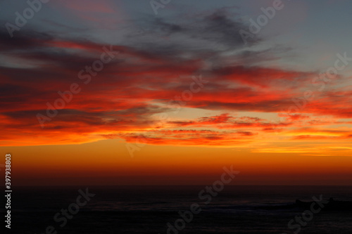 sunset with the reddish sun near the sea © Imaxepress