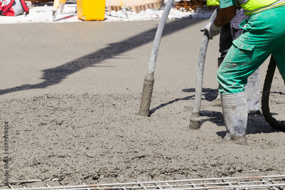 workers stirring cement with hoses workers stirring cement with hoses
