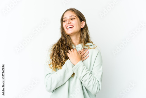 Young caucasian woman laughing keeping hands on heart, concept of happiness. © Asier