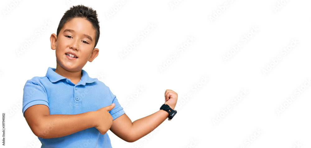 Little boy hispanic kid wearing casual clothes pointing to the back behind with hand and thumbs up, smiling confident