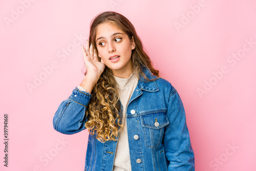 Young caucasian woman trying to listening a gossip. © Asier