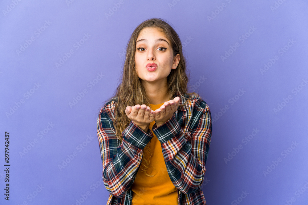 Young caucasian cute woman folding lips and holding palms to send air kiss. Young caucasian cute woman folding lips and holding palms to send air kiss.